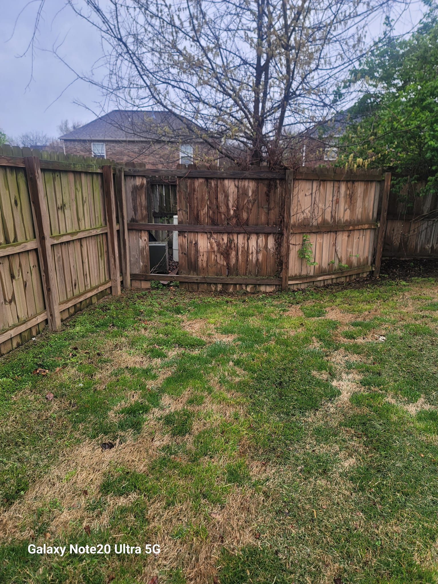Worn wood fence with a damaged section in need of repair